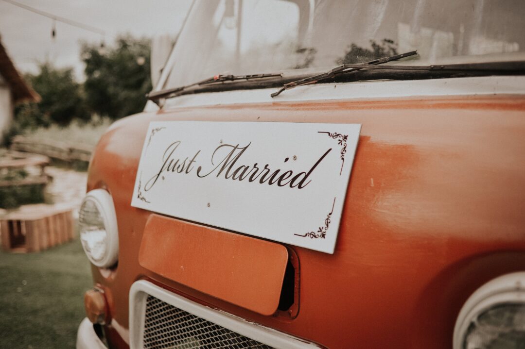 A just married plank on a red van prepared for newlyweds.