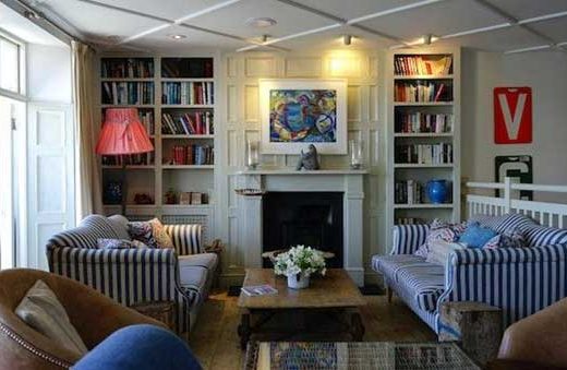 A living room with a fireplace and bookshelves